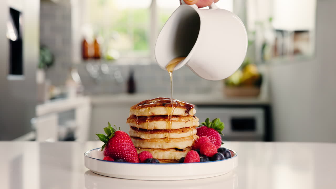 Sciroppo versato su una pila di pancake con frutti di bosco freschi