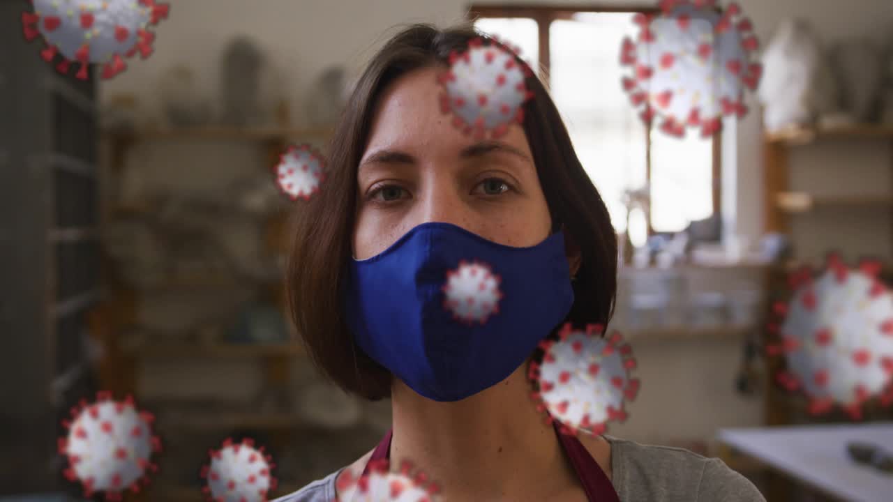 Ceramic maker turning as camera rising, revealing mask as virus icons filling, showing health risk