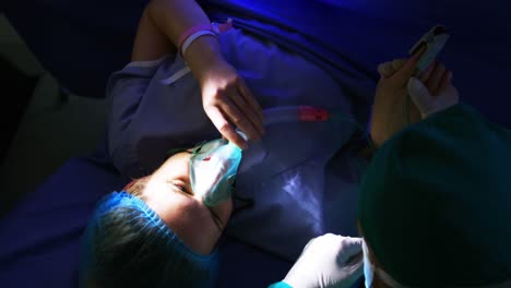 médico examinando a una mujer embarazada en el quirófano