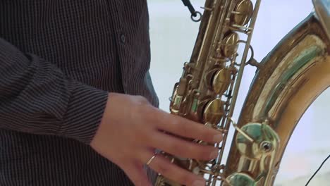 saxophonist plays the saxophone close up