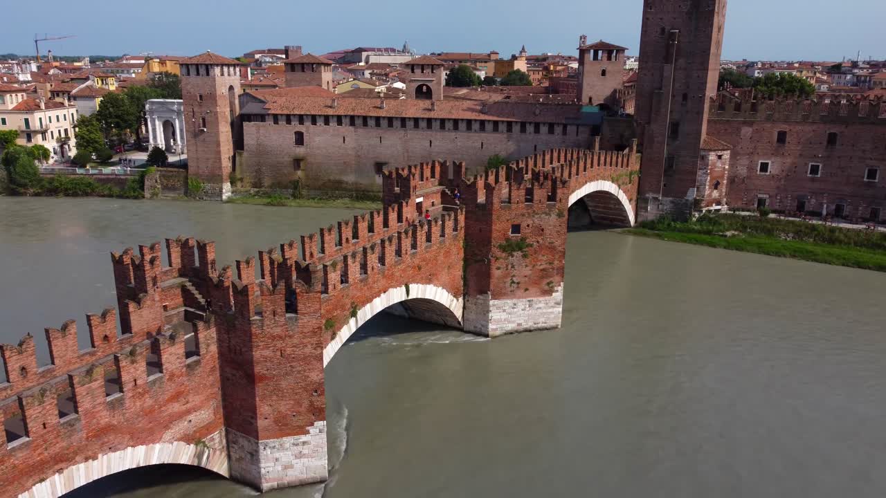 Kinowy dron krążący wokół Ponte Scaligero i Castelvecchio w letnim słońcu - Włochy