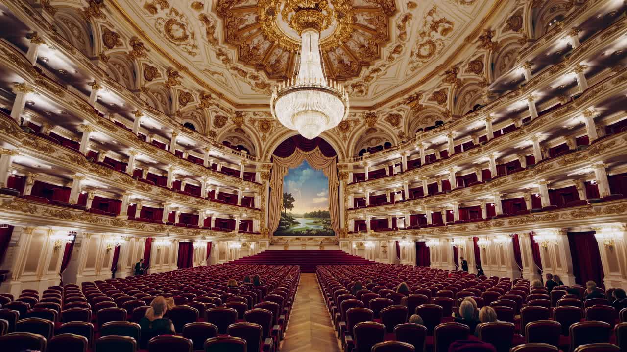 Wide-angle shot of an opulent theater interior with ornate decor and grand chandelier, perfect