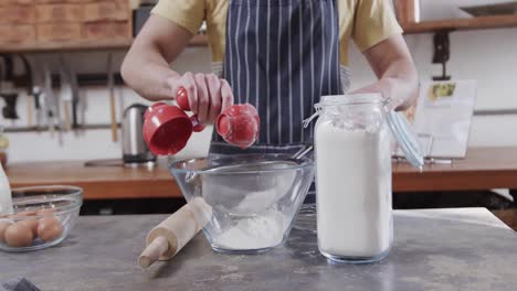 midsection of caucasian man preparing bread dough in kitchen, slow motion