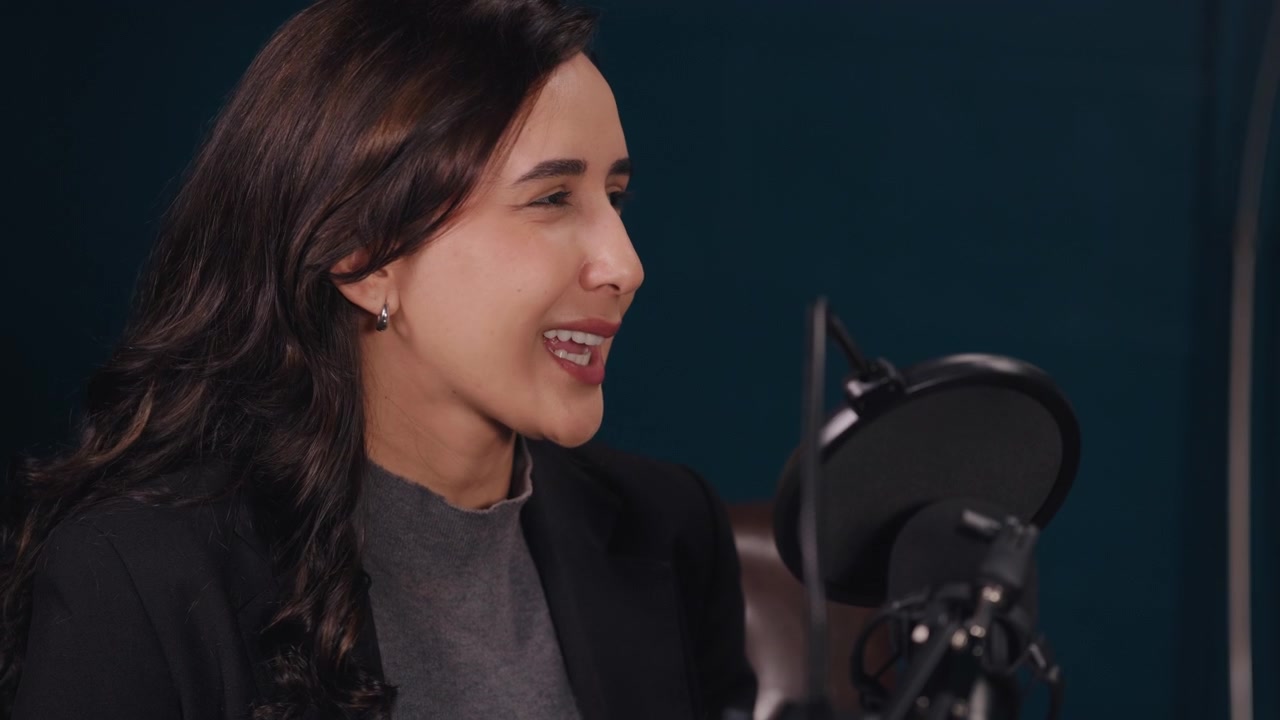Giovane donna che parla al microfono in un ambiente di studio professionale