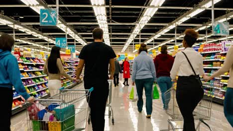 in a lively supermarket, families and friends navigate colorful aisles filled with various products. shoppers push carts while examining items on the shelves. the atmosphere buzzes with conversations, laughter, and the sounds of carts rolling on polished floors. bright lights illuminate displays of