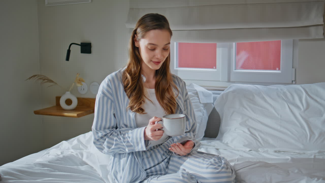 Woman enjoy morning routine holding coffee cup on bedding closeup. Happy lady