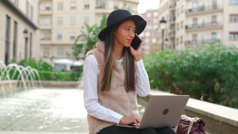 Mujer-Hispana-Navegando-Por-Computadora-Portátil-En-La-Calle