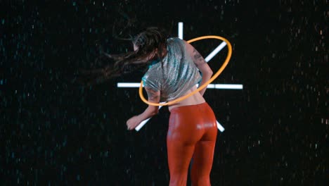 amazing hula hooping skills, female hula hooper performing body workout in wet studio