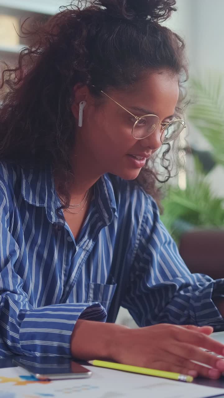 Young woman engages in lively online discussion from her cozy workspace