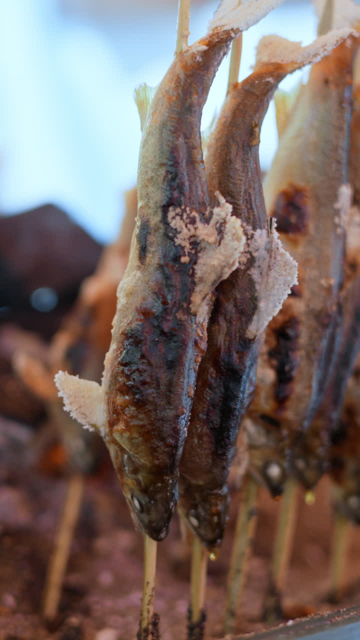 Close up of smoked fish at a street food market in Japan. Vertical
