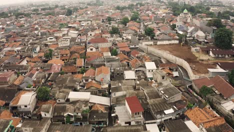 aerial flyover park beside poor slum district with old houses in jakarta city, indonesia - establishing drone shot