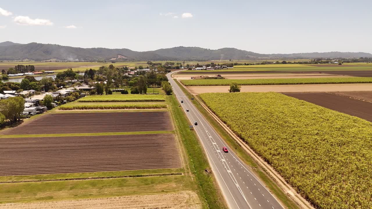 Tráfico circulando por Tweed Valley Way cerca de campos de caña en el norte de Nueva Gales del Sur