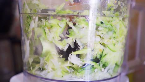 slow motion closeup of a food processor chopping zucchini