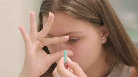 young girl place the contact lens in the front from the mirror with doctor. inserting contact lens. night time contact lenses