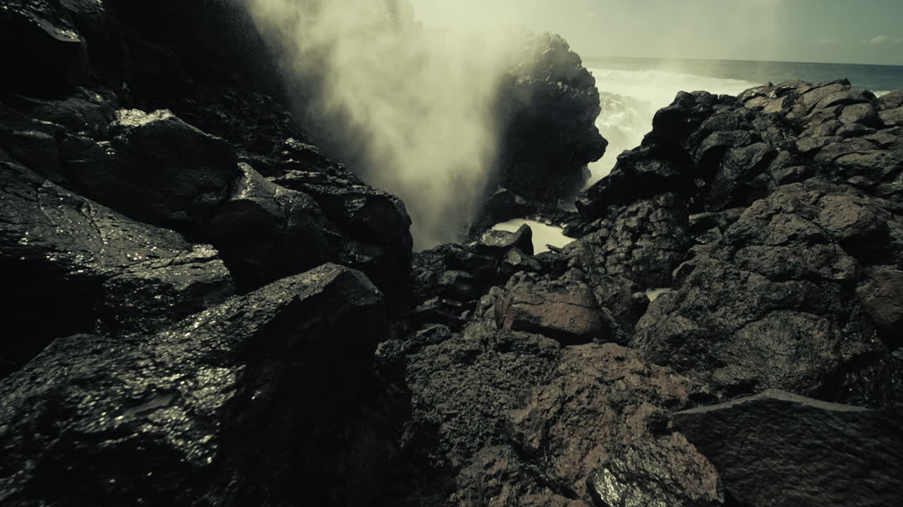 강력한 파도가 화산암에 부히고