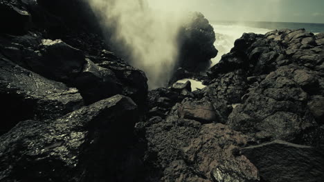 powerful waves crashing against volcanic rocks