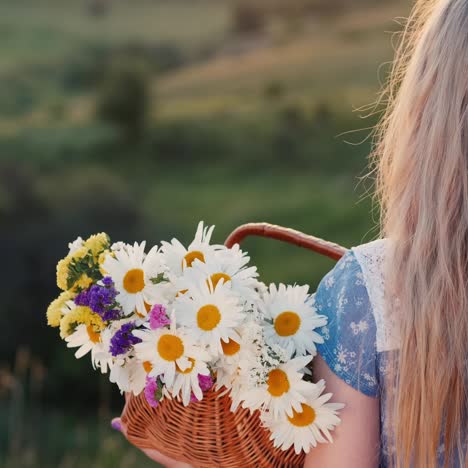 a child holds a basket of flowers stands in a meadows and green hills 2