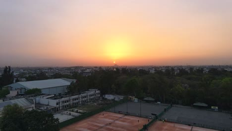 4K-Drohnenaufnahmen-Eines-Sonnenuntergangs-In-Einer-Indischen-Stadt,-Neu-Delhi,-über-Bäumen-Und-Häusern,-Schöne,-Helle-Punjabi-Bagh-Club,-Noble-Kolonie