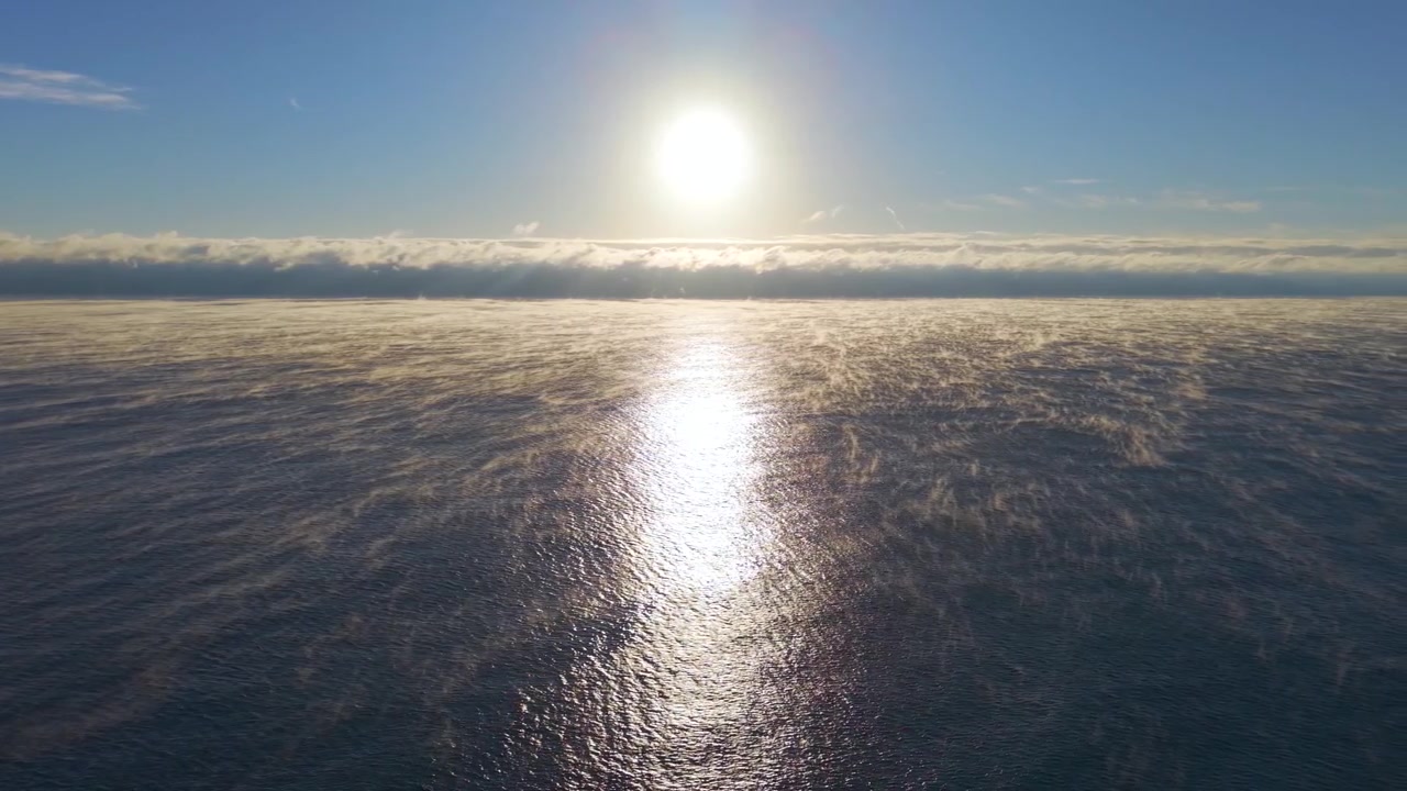 Sakte luftpanorering over havet ved Deerfield Beach ved soloppgang en kald morgen med surrealistisk tåke som stiger opp fra vannet og solen sentrert på horisonten.