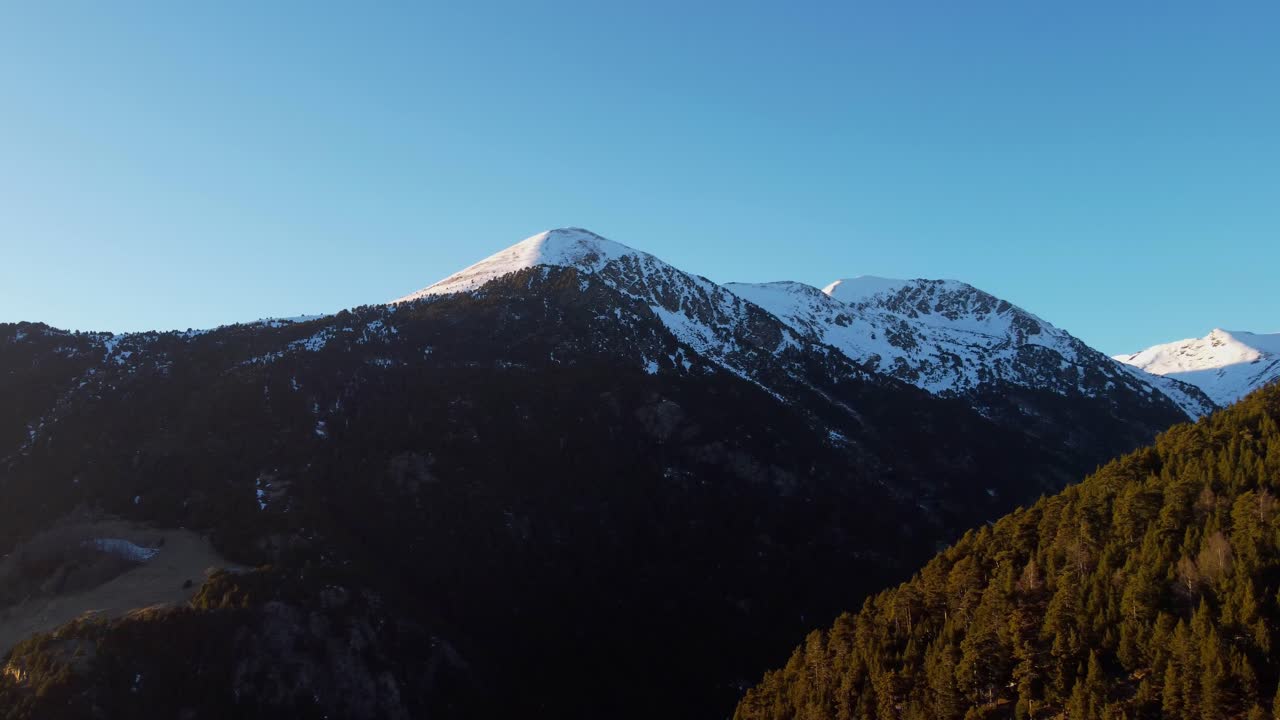 4K Drone Pan from Snowy Mountain Summit to Forested Valley in Andorra at Sunset