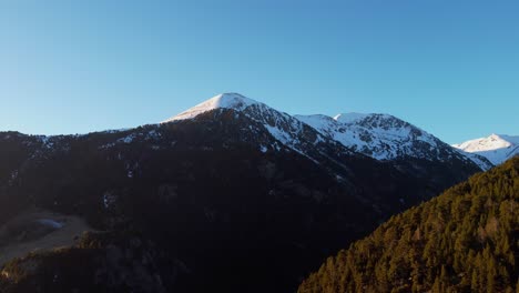 4K Drone Pan from Snowy Mountain Summit to Forested Valley in Andorra at Sunset