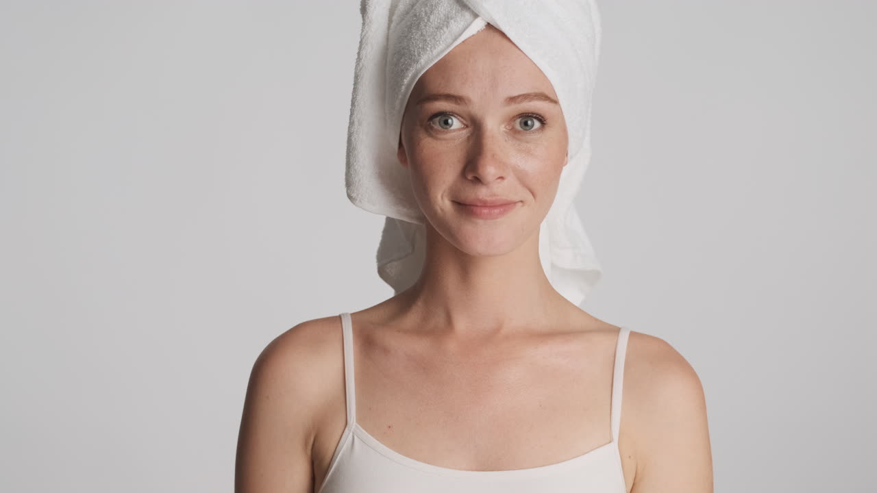 Caucasian woman wearing towel on her head.