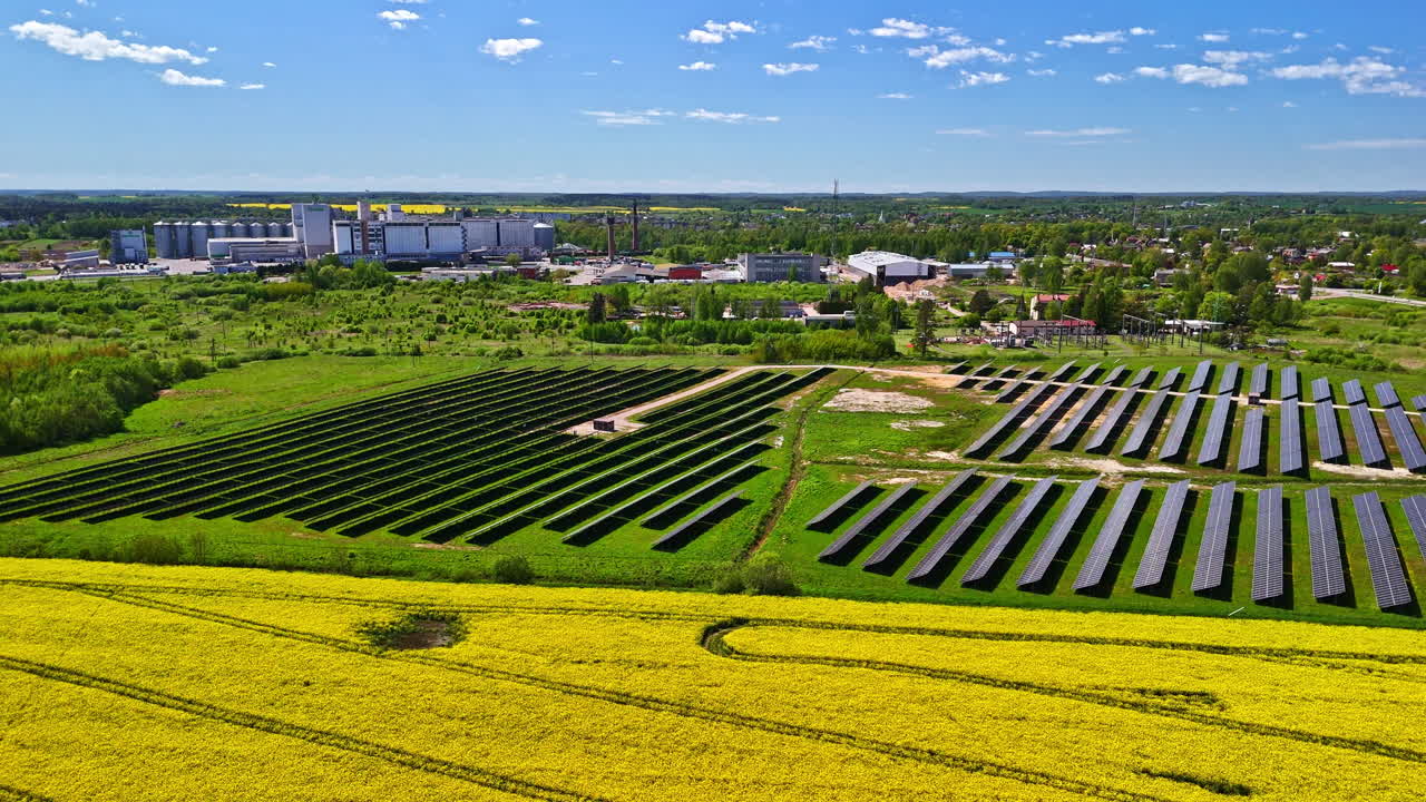 Golden rapeseed fields and solar panels, aerial drone orbit view