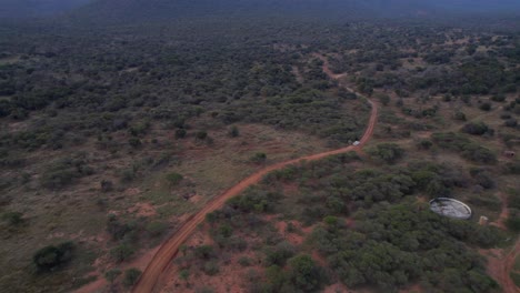 4x4 suv white vehicle driving a dirty road in african game reserve farm