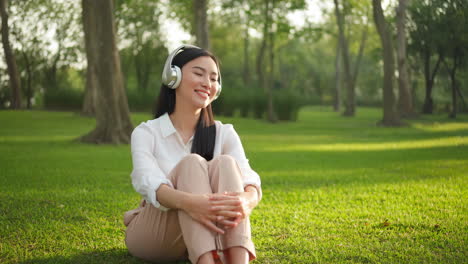 woman relaxing in park with headphones