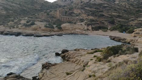 cabo de huertas coastline with ancient ruins and a person walking by the shore