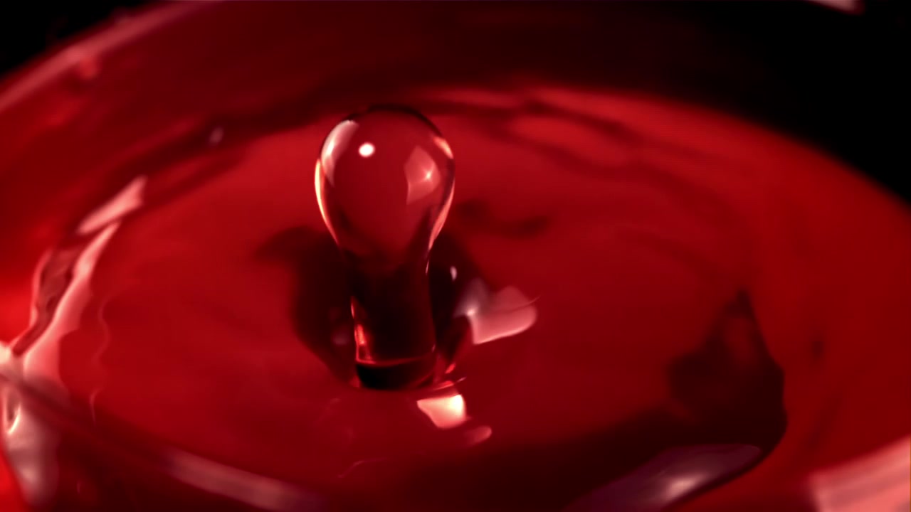 Close-Up of a Red Liquid Drop Splashing in Slow Motion
