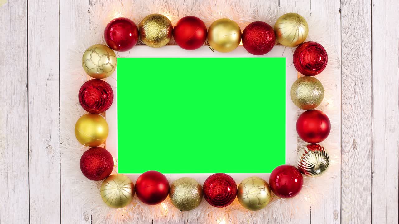 decoración de navidad con bolas doradas y rojas y luces parpadeantes alrededor del marco con pantalla verde. detenga el movimiento