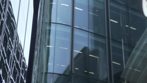 close shot with slow travelling a plane reflecting in the glass of the buildings of the city of london
