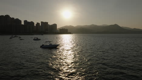 Vista-Aérea-De-La-Puesta-De-Sol-Sobre-El-Océano-Con-La-Silueta-Del-Horizonte-De-La-Metrópolis-China-De-Hong-Kong