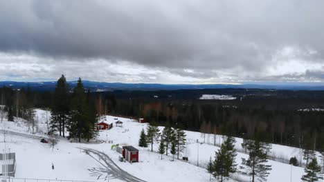 Disparo-De-Drone-Inclinándose-Hacia-Abajo-Junto-A-Un-Campo-Lleno-De-Nieve