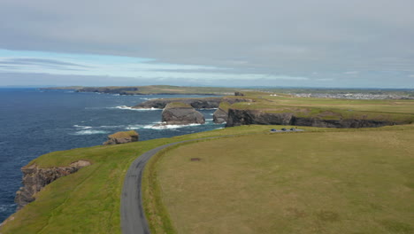 Vuela-Sobre-La-Pradera-Sobre-Los-Altos-Acantilados-Que-Caen-Abruptamente-A-La-Superficie-Del-Mar.-Imágenes-Panorámicas-Aéreas-De-Hitos-Naturales.-Paseo-Del-Acantilado-De-Kilkee,-Irlanda