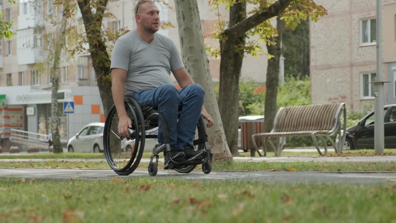 hombre con discapacidad en silla de ruedas camina por el callejón del parque