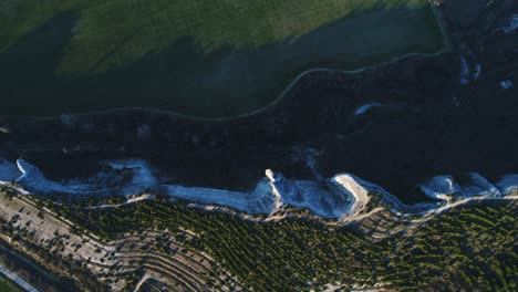 aerial view of a dramatic landscape with cliffs and fields