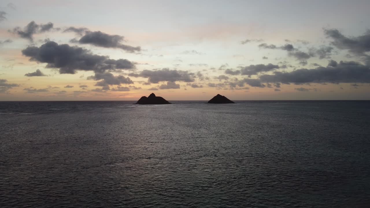 toma de drone de grúa cinematográfica de 4k de dos islas y el océano desde la playa de lanikai en oahu durante el amanecer