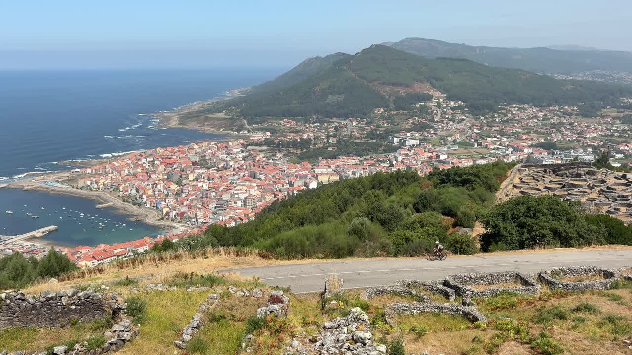 Cyclist climbing Santa Tecla hill in A Guarda northern Spanish village