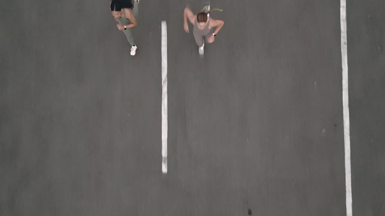 Due donne che fanno jogging in un parcheggio