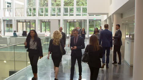 businesspeople in busy lobby area of modern office shot on r3d