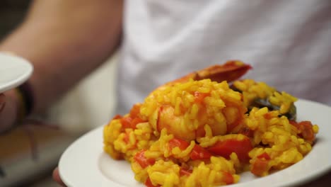 Plate-of-paella---prawns,-shrimps,-mussels,-rice-and-tomatoes---close-up