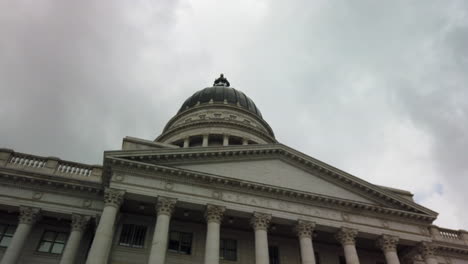 a beautiful smooth hyper lapse or time lapse of a camera passing in front of the utah state capital building as clouds move quickly in the background