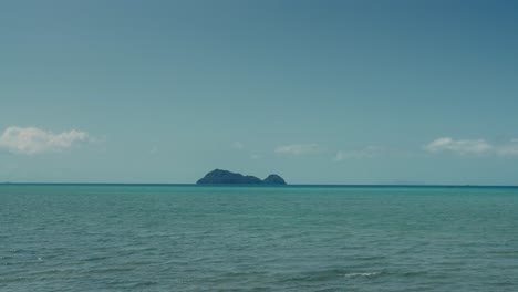 steady seascape view with blue sky and sea and island on horizon