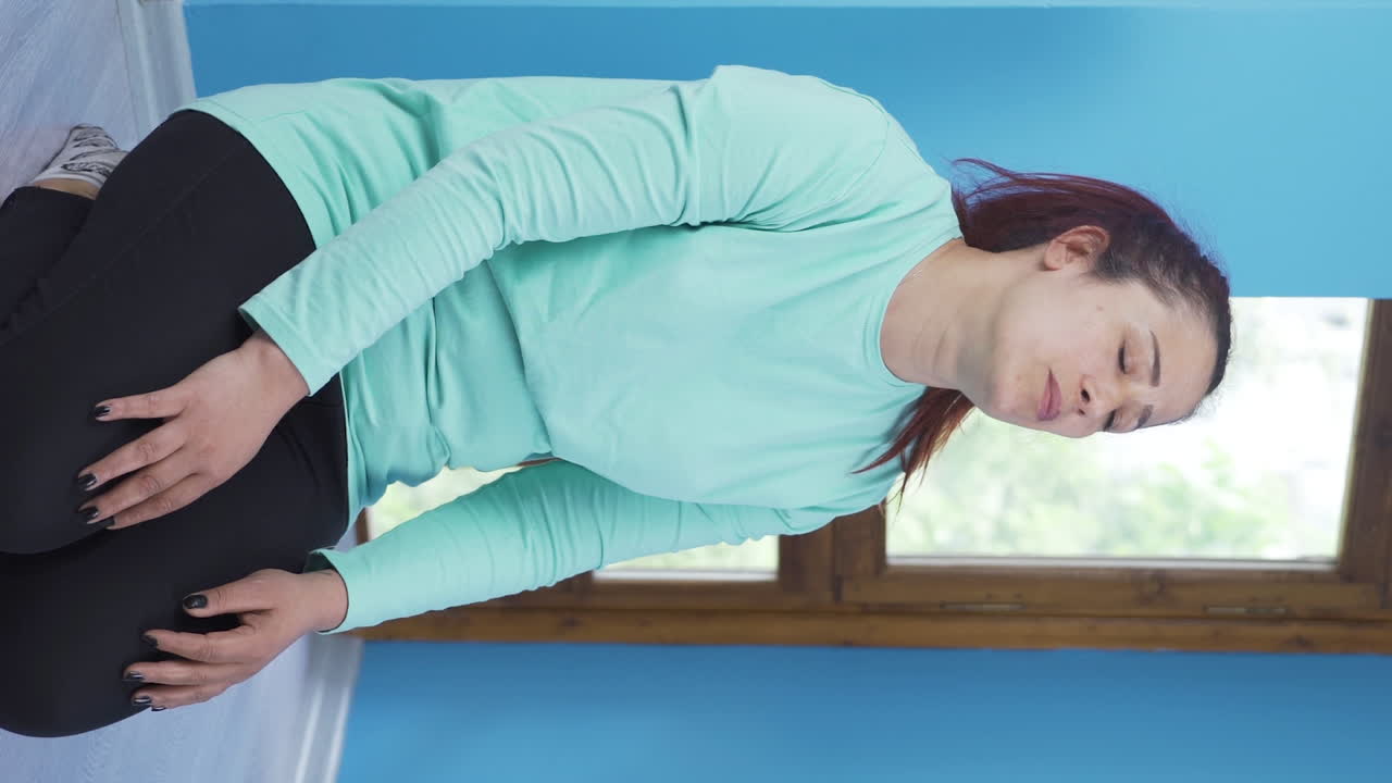 무 ⁇ 을  ⁇ 고 있는 불행한 여자의 수직 비디오. 지쳐있어요.