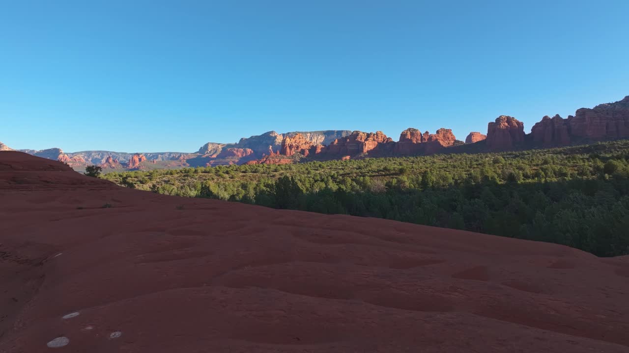 drone vuela a lo largo de la cornisa de piedra arenisca sobre el bosque a la roca submarina, sedona arizona