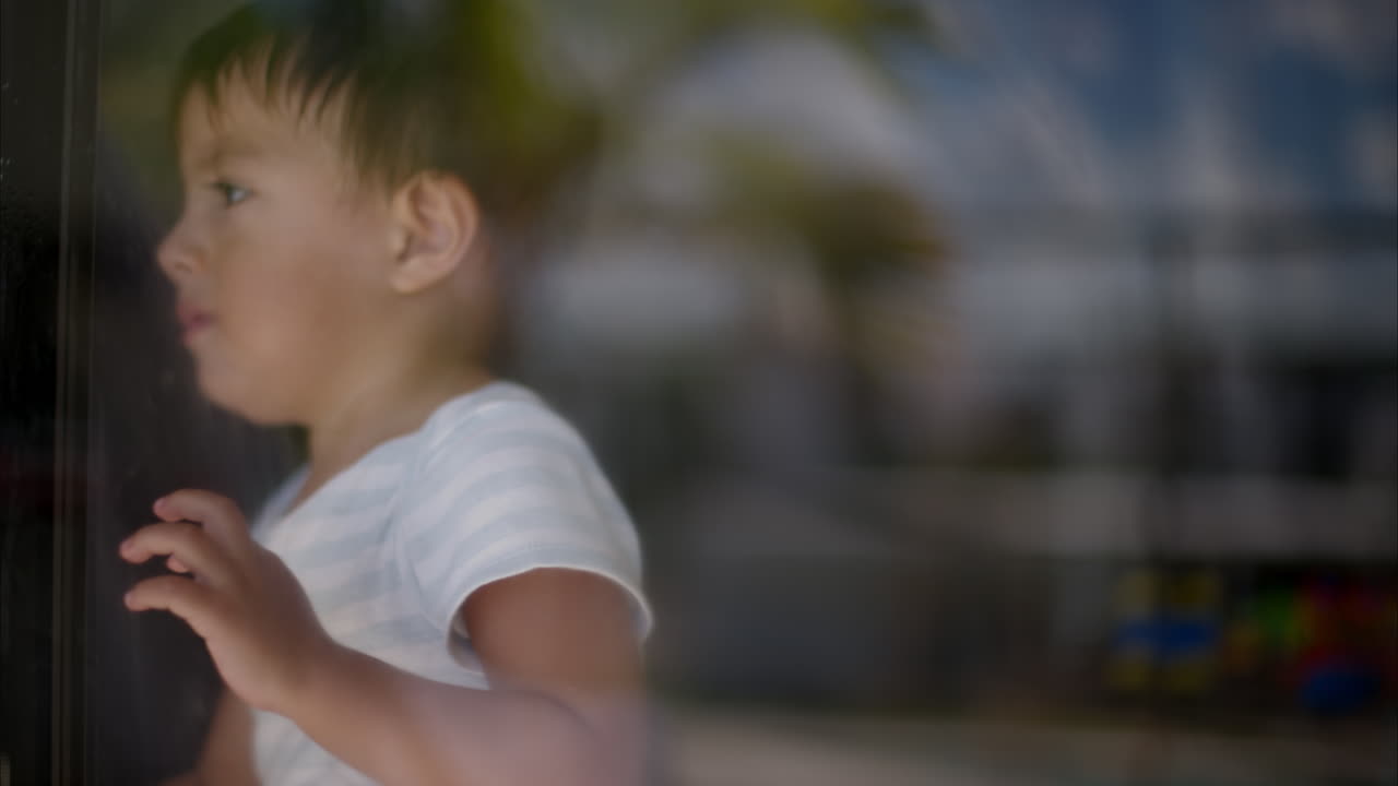 집안일을 하고 창문을 청소하고 따뜻하고 화창한 아침에 웃고 있는 귀여운 라틴계 소년