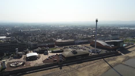 Popular-seaside-Rhyl-resort-holiday-promenade-town-aerial-dolly-right-view-above-coastal-beach-attraction