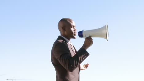 Empresario-Afroamericano-Dando-Instrucciones-A-Través-De-Megáfono